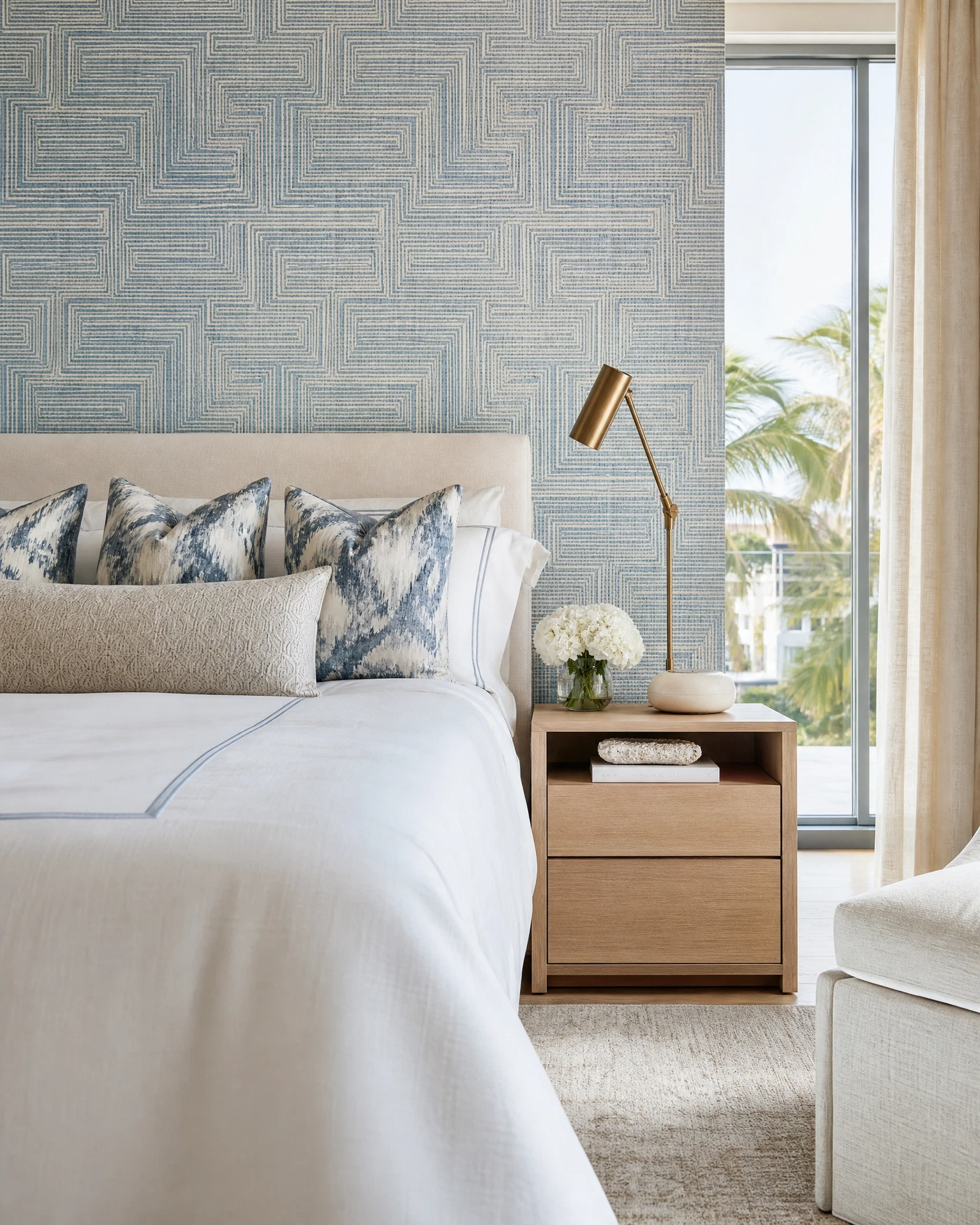 Blue geometric wallpaper in a bright condo bedroom
